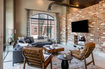a living room with a brick wall and a large window